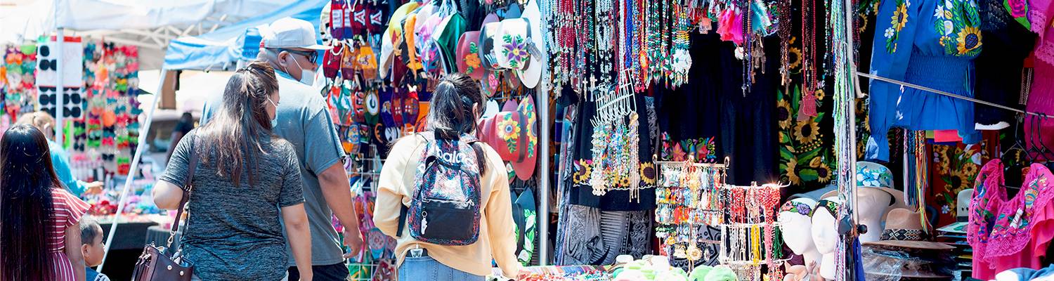People shopping at outdoor vendor booth
